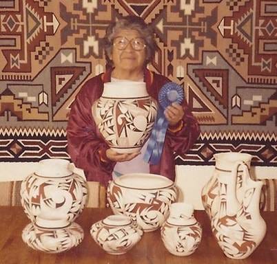 An old person holding a large vase

Description automatically generated