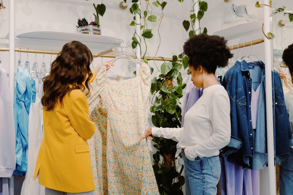 Two women looking at a dress in a shop Two women looking at a dress in a shop
