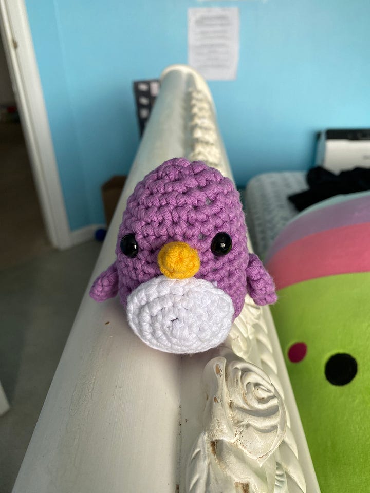 A purple penguin and a rainbow narwhal, crocheted using Woobles kits.