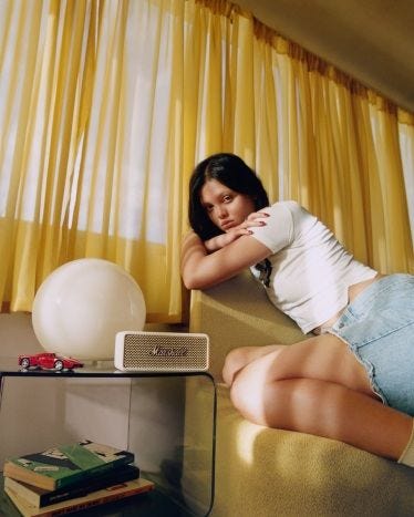 This may contain: a woman sitting on top of a couch next to a window