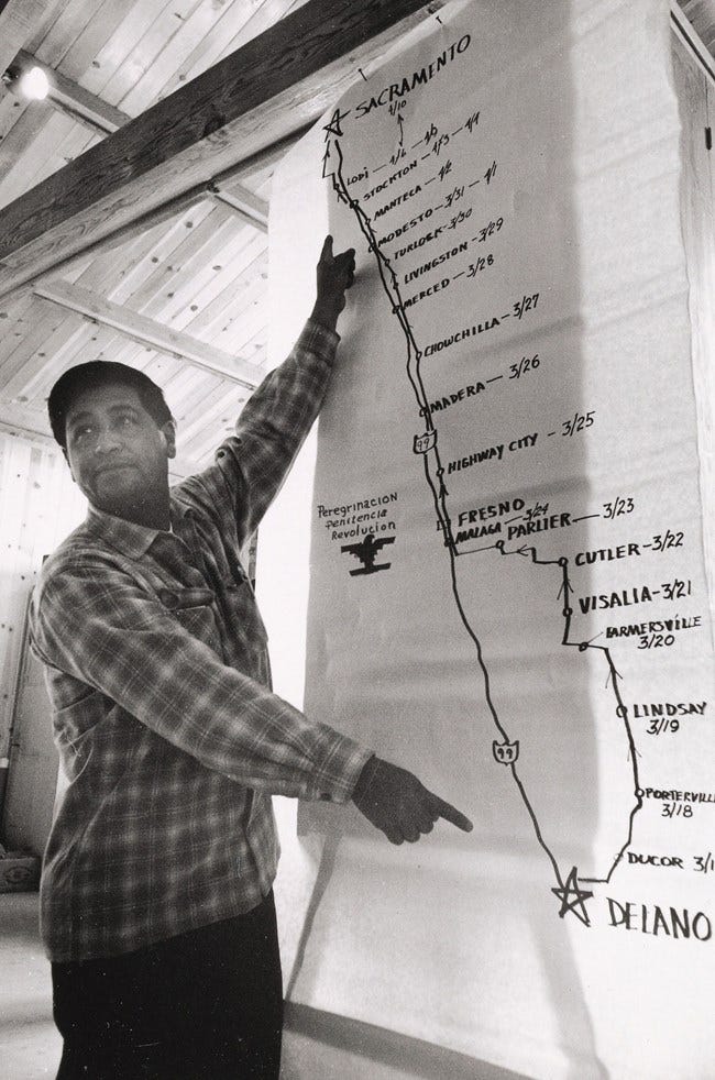 Cesar Chavez stands in front of a map of 1966 march route.