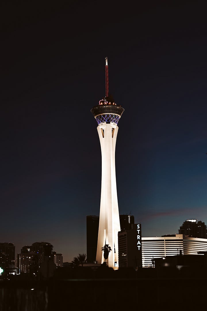 a polaroid of a manifestation napkin sits on top of said napkin inside a journal with graph paper. a fine art print of the stratosphere from downtown las vegas.
