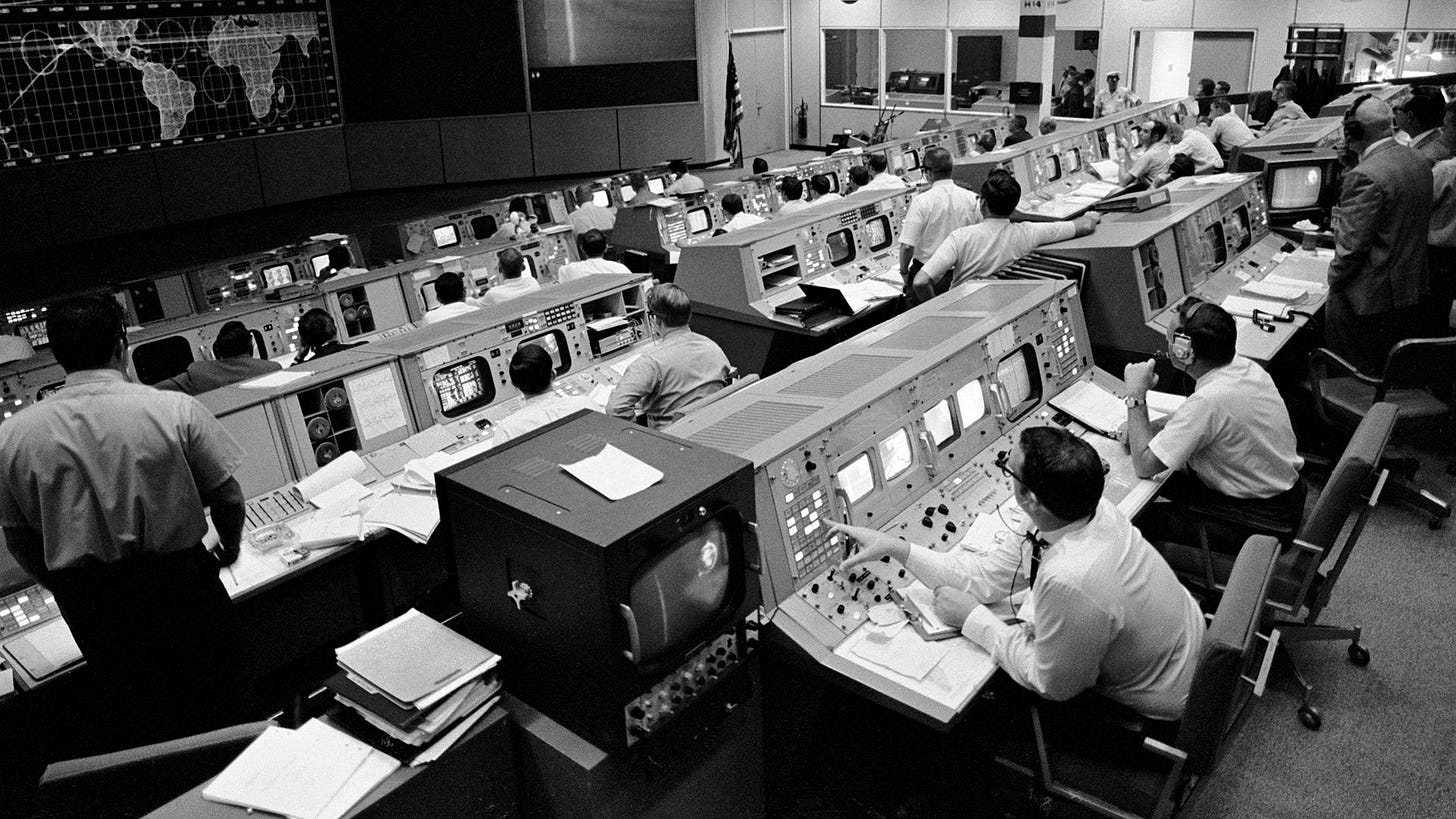 Schwarz-weiß Foto vom Missions-Kontroll-Zentrum der Apollo Mondmissionen der NASA.