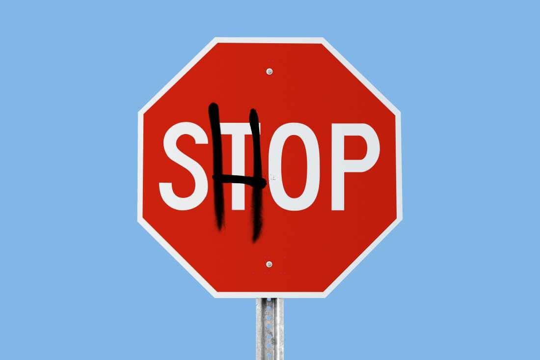 Photo illustration of a stop sign that reads "STOP" with the "T" covered by a graffitied "H" in black spray paint, so that the sign then reads "SHOP," illustrating the idea of lowering your consumerism, or stopping shopping. 