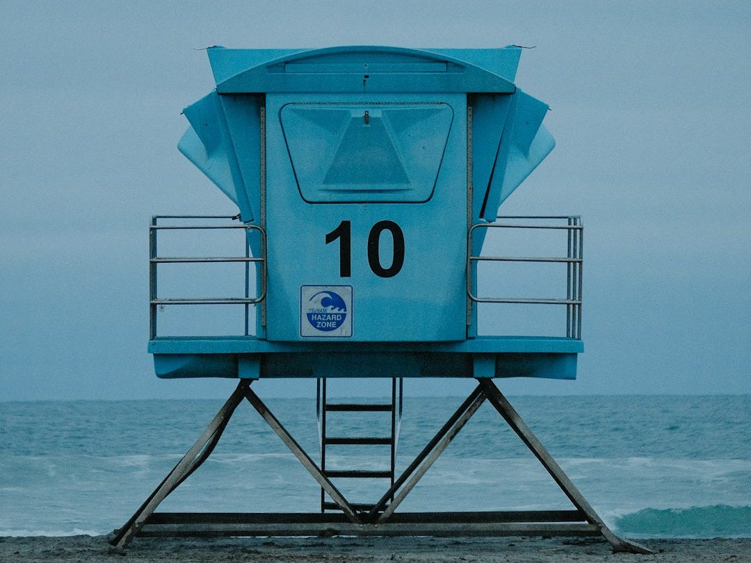 a lifeguard tower sitting on top of a sandy beach