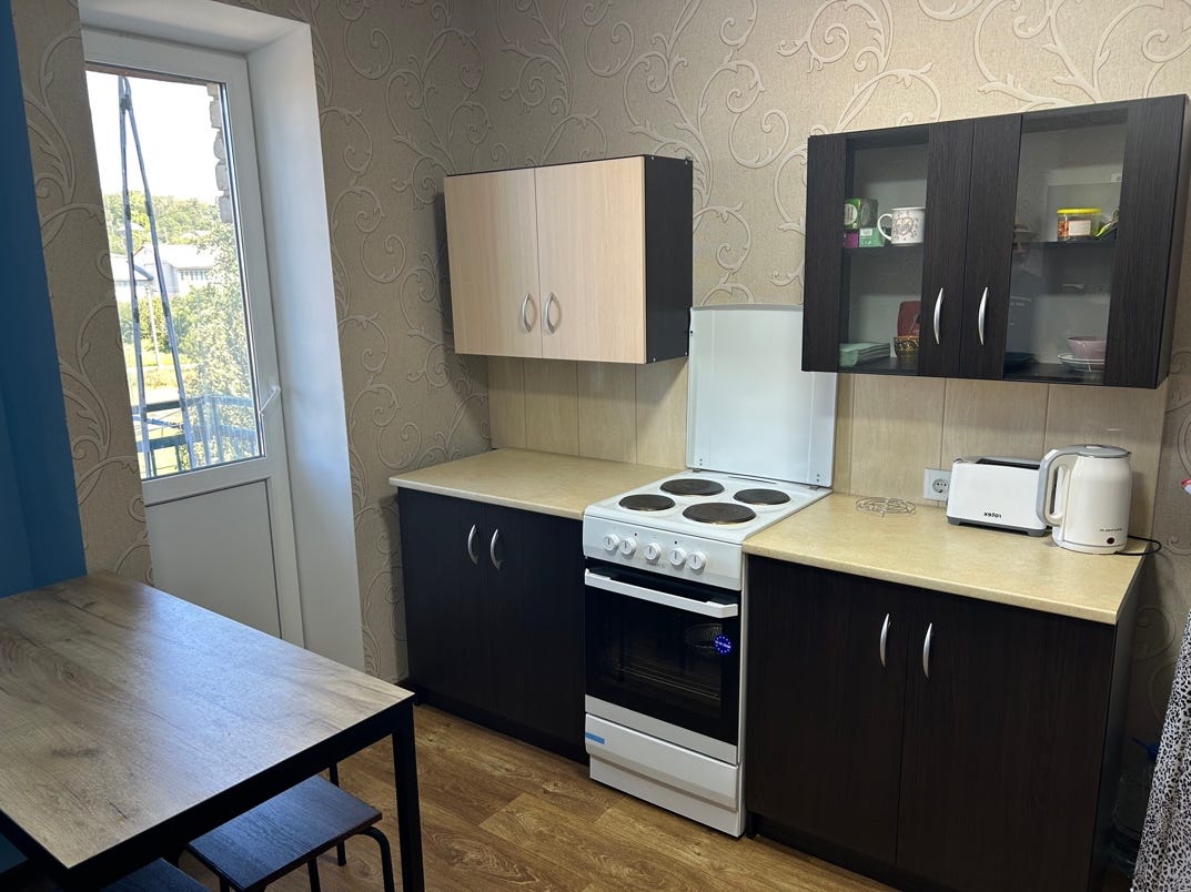 A kitchen with a table and chairs

AI-generated content may be incorrect.
