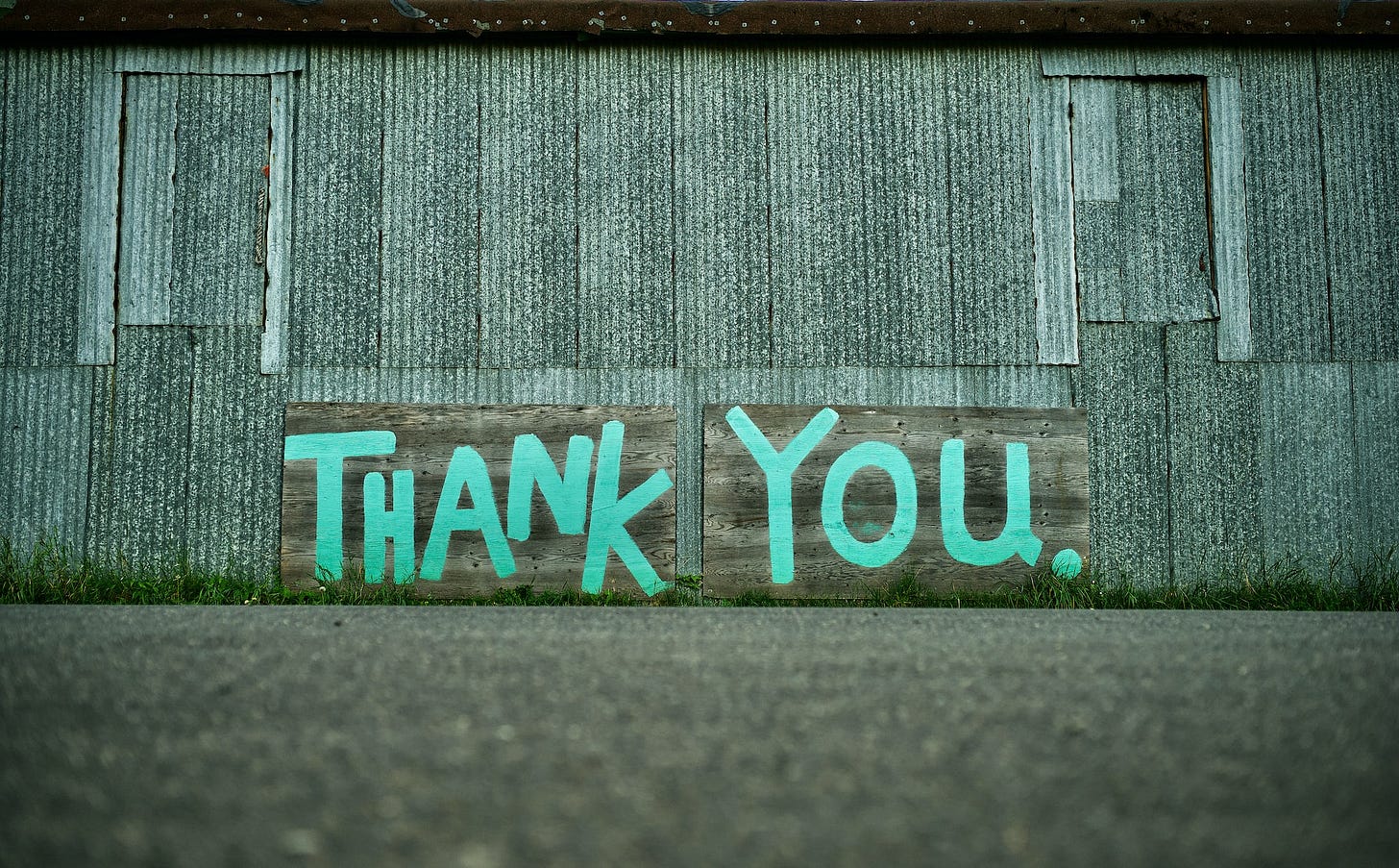 Metal sided building with Thank You painted on the side in blue paint. Metal sided building with Thank You painted on the side in blue paint.