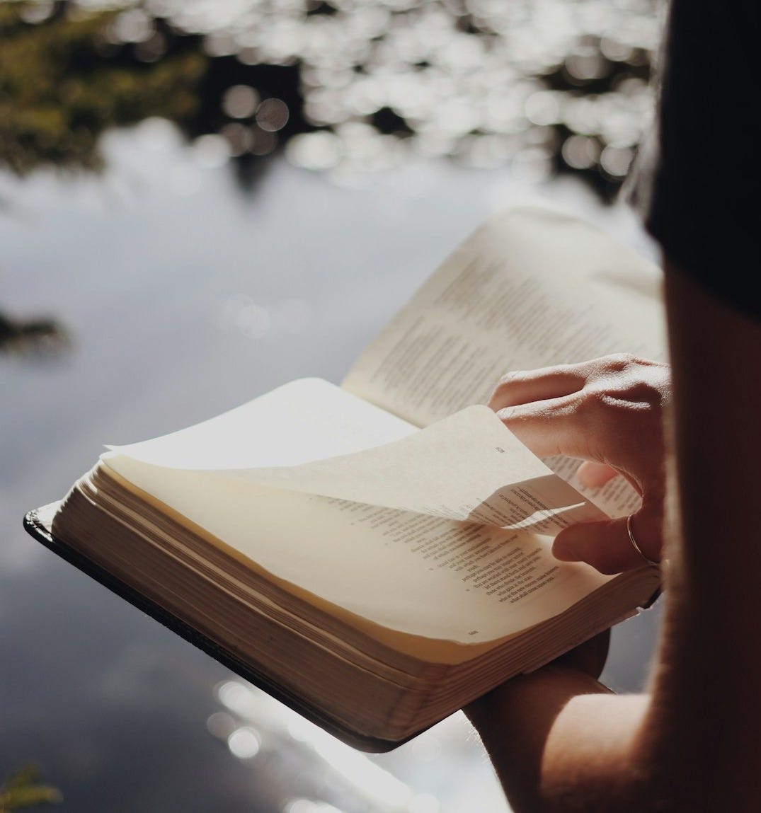 person in black long sleeve shirt holding book