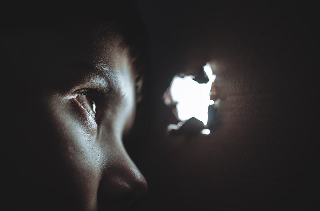 person watching through hole person watching through hole