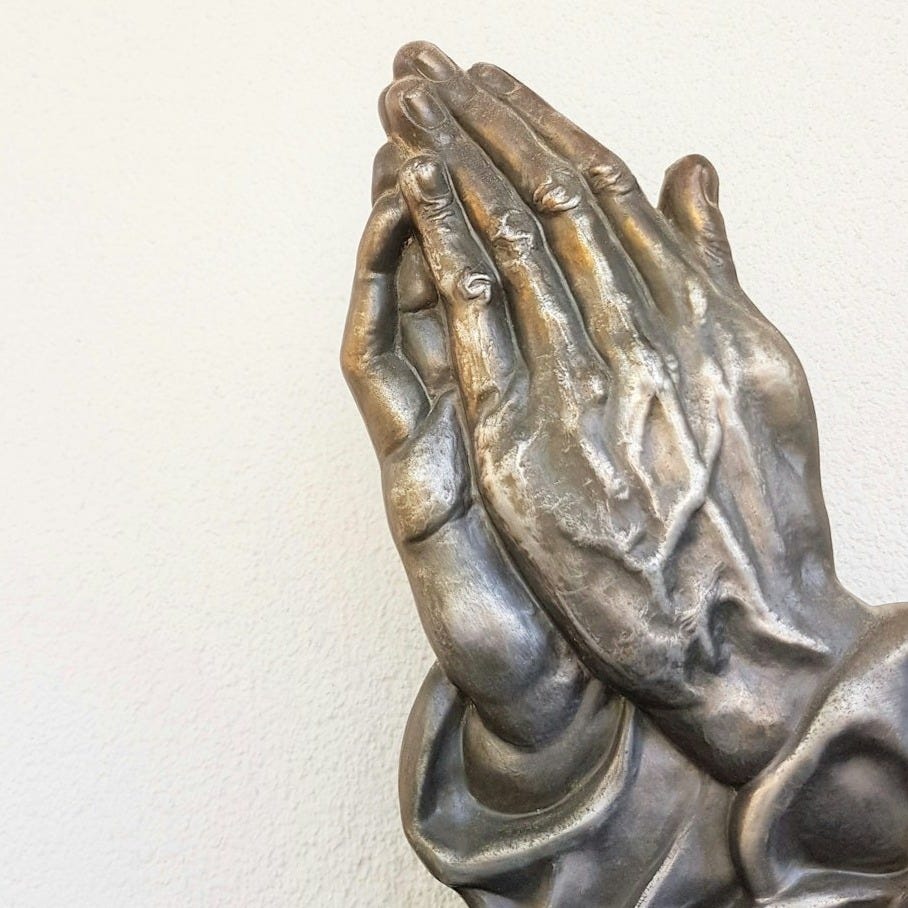 gray praying hand statue