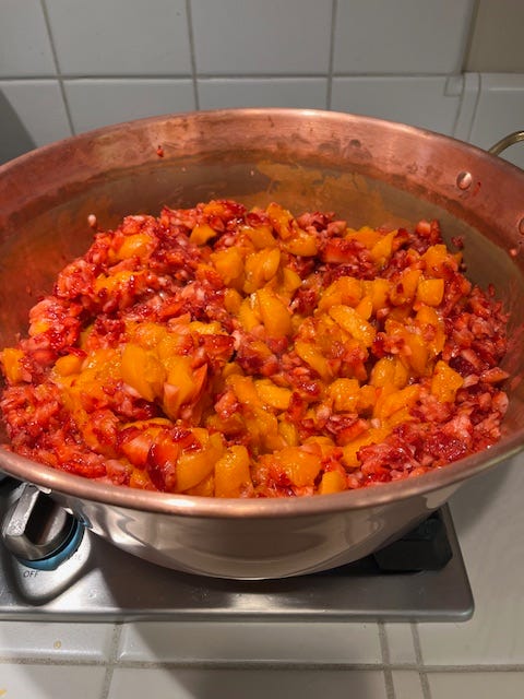 Copper jam pot filled with apricots and strawberries