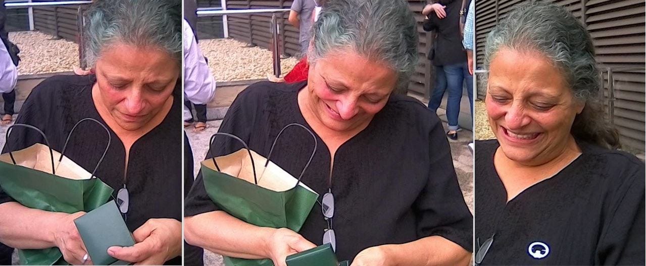 A candid series of Ane Walsh smiling and opening a gift, outdoors and surrounded by colleagues