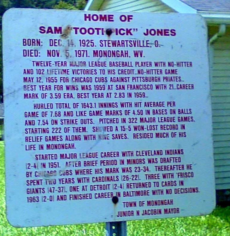 A white sign with red capital letters says: Home of Sam “Toothpick” Jones. Born Dec 14. 2025. Stewartsville, O. Died: Nov 5, 1971. Monongah, WV. Twelve-year major league baseball player with no-hitter and 102 lifetime victories to his credit…no-hitter game May 12, 1955 for Chicago Cubs against Pittsburgh Pirates…Best year for wins was 1959 at San Francisco with 21…career mark of 3.59 ERA. Best year at 2.83 in 1959… Hurled total of 1643.1 innings with hit average per game of 7.68 and like game marks of 4.50 in bases on balls and 7.54 on strike outs. Pitched in 322 major league games starting 222 of them. Showed a 15-5 won-lost record in relief games along with nine saves. Resided much of his life in Monongah. Started major league career with Cleveland Indians (2-4) in 1951. After brief period in minors was drafted by Chicago Cubs where his mark was 23-34. Thereafter he spent two years with Cardinals (26-22). Three with ‘Frisco Giants (47-37). One at Detroit (2-4) Returned to Cards in 1963 (2-0) and finished career in Baltimore with no decisions. Town of Monongah Junior N Jacobin Mayor.