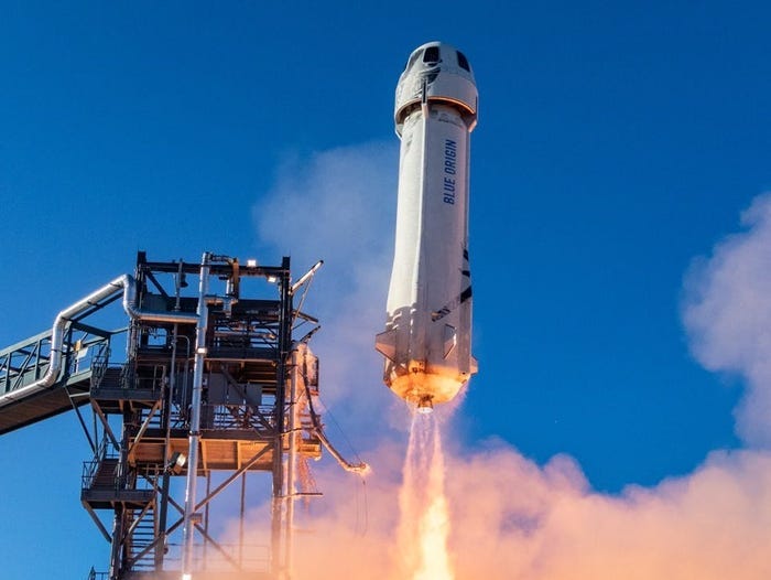 A blue origin new shepard rocket launches, leaving behind exhaust A blue origin new shepard rocket launches, leaving behind exhaust