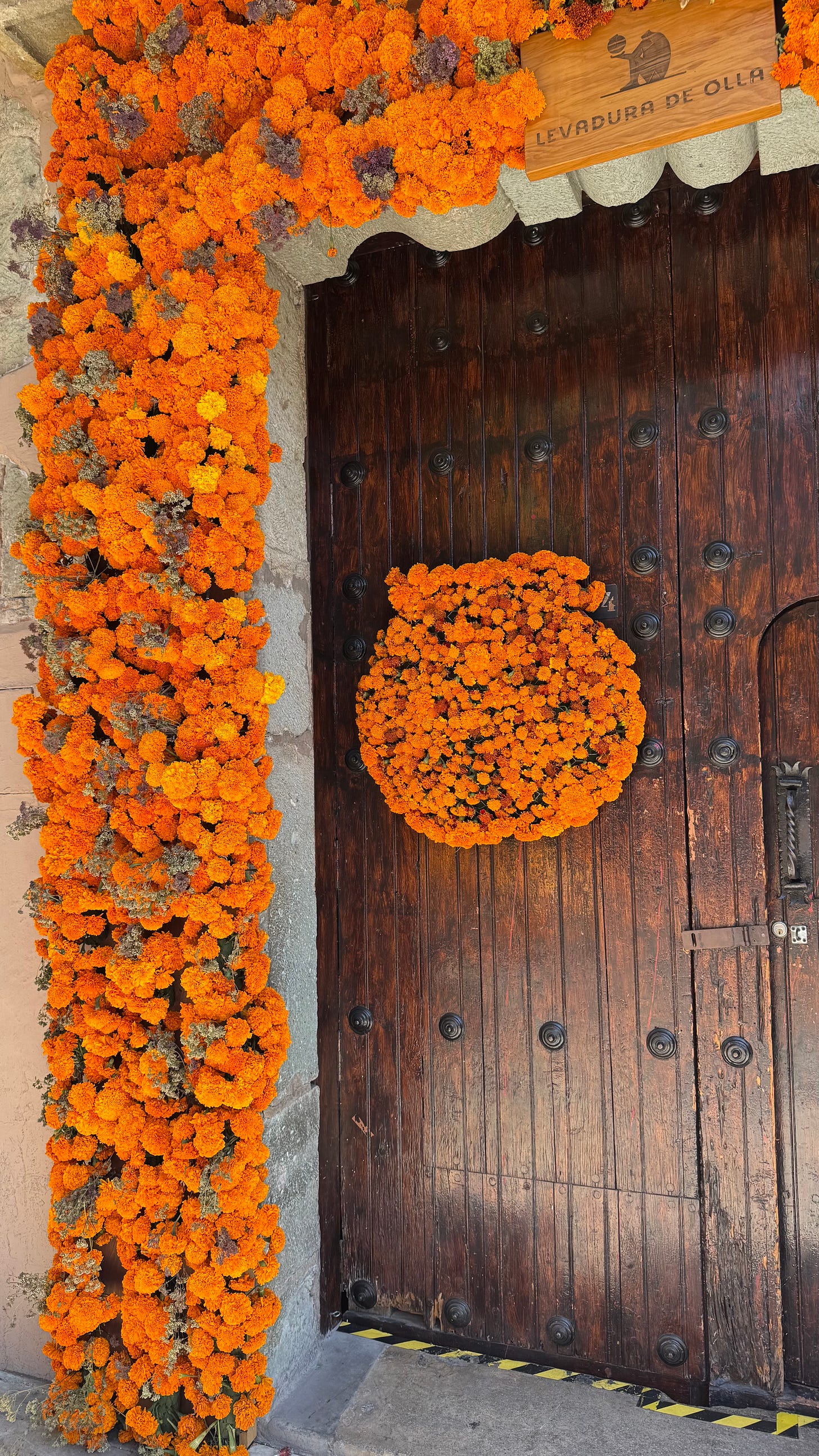 A wood door surrounded by marigolds.