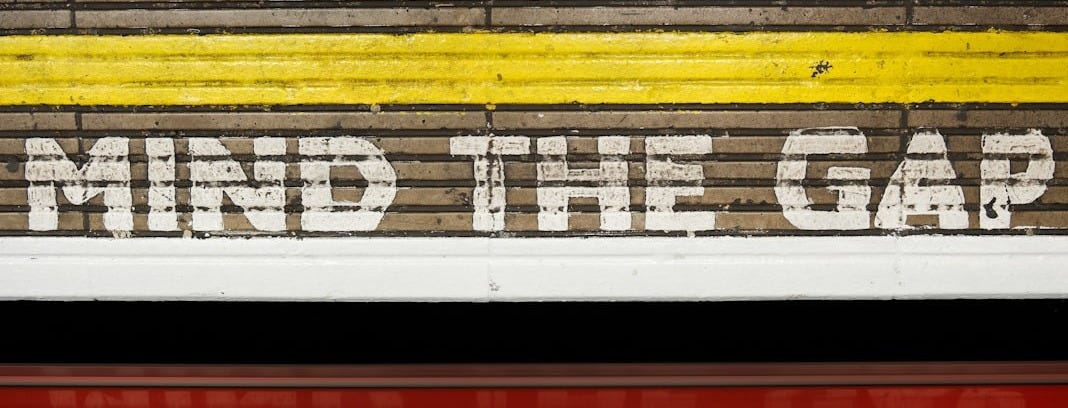 A sign that says mind the gap on the side of a train A sign that says mind the gap on the side of a train