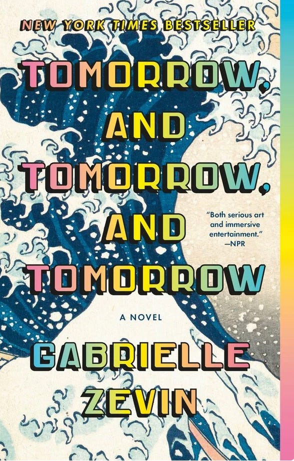 Cover of novel by Gabrielle Zevin called Tomorrow, Tomorrow, and Tomorrow. Title is overlayed on background of poster art that depicts a kind of moutnain with a dark cloud above. main colors are greens, yellows, reds and black