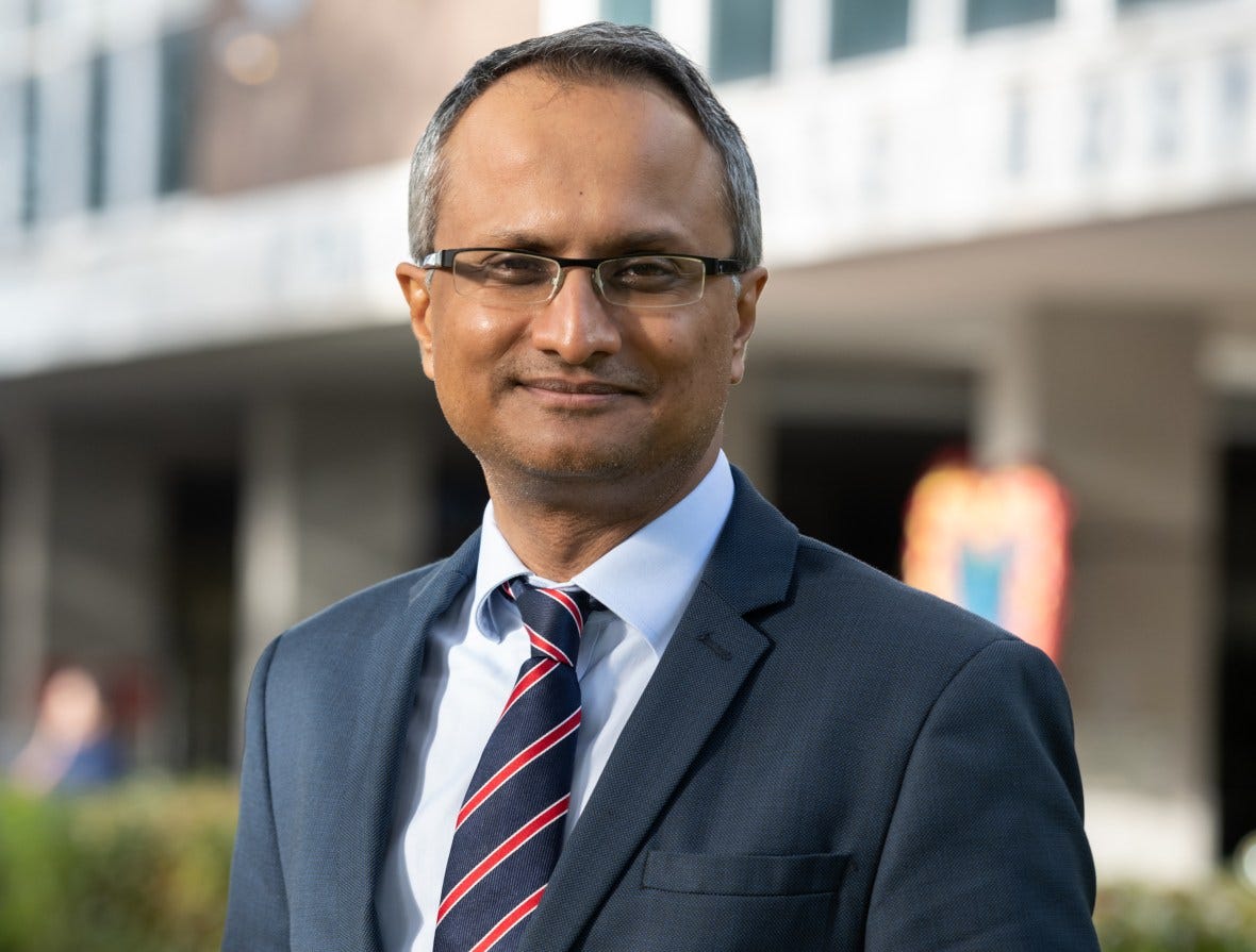 Professor Hashim U Ahmed wearing a suit and tie.