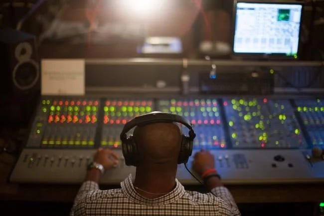 Mix engineer adjusting input gain levels on audio interface and DAW meters