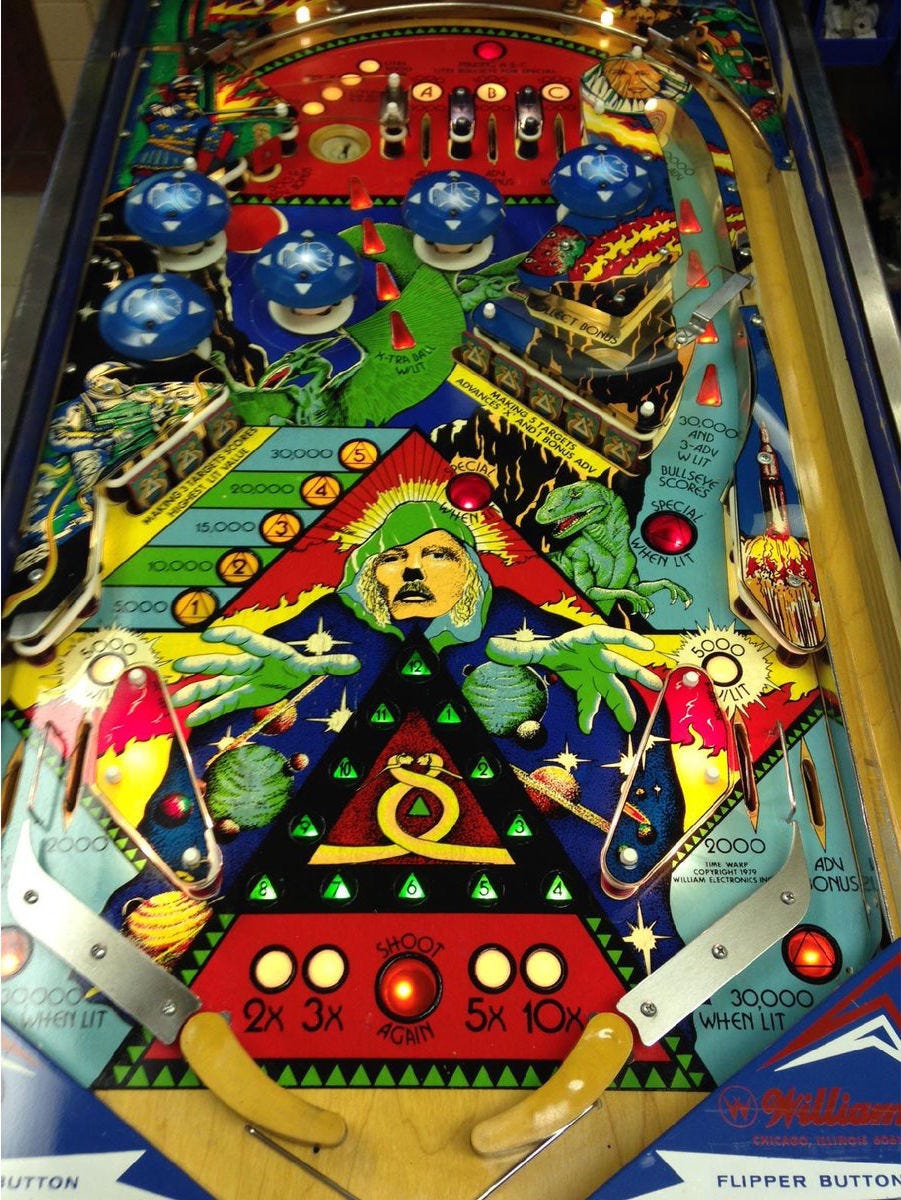 Top down view of the table for TIME WARP featuring art resembling artist Michael Whelan. The game mechanics feature unique banana-shaped curved paddles.