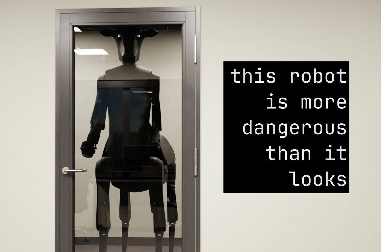 The robot is standing behind a glass door; it's so tall that its eyes are nearly at the top of the frame. They are white with pinpoint black pupils and are unblinking. Text next to the robot says "this robot is more dangerous than it looks"