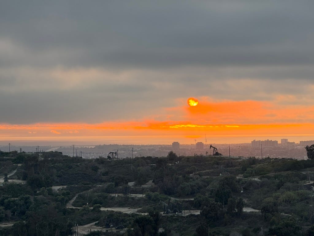 A sunset over a city

Description automatically generated