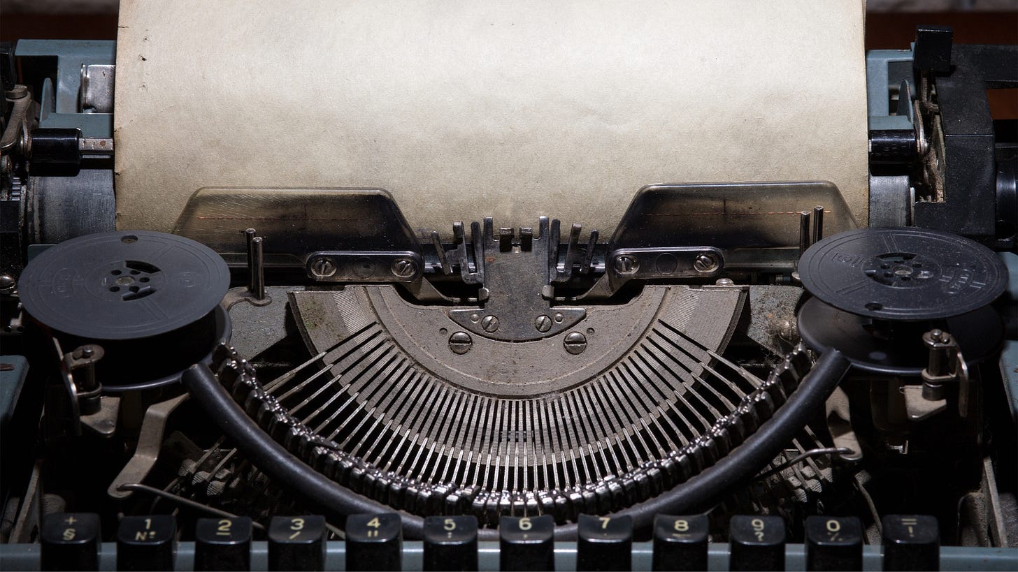 Close-up of vintage typewriter striking rods and a weathered blank paper loaded into the roller. Close-up of vintage typewriter striking rods and a weathered blank paper loaded into the roller.