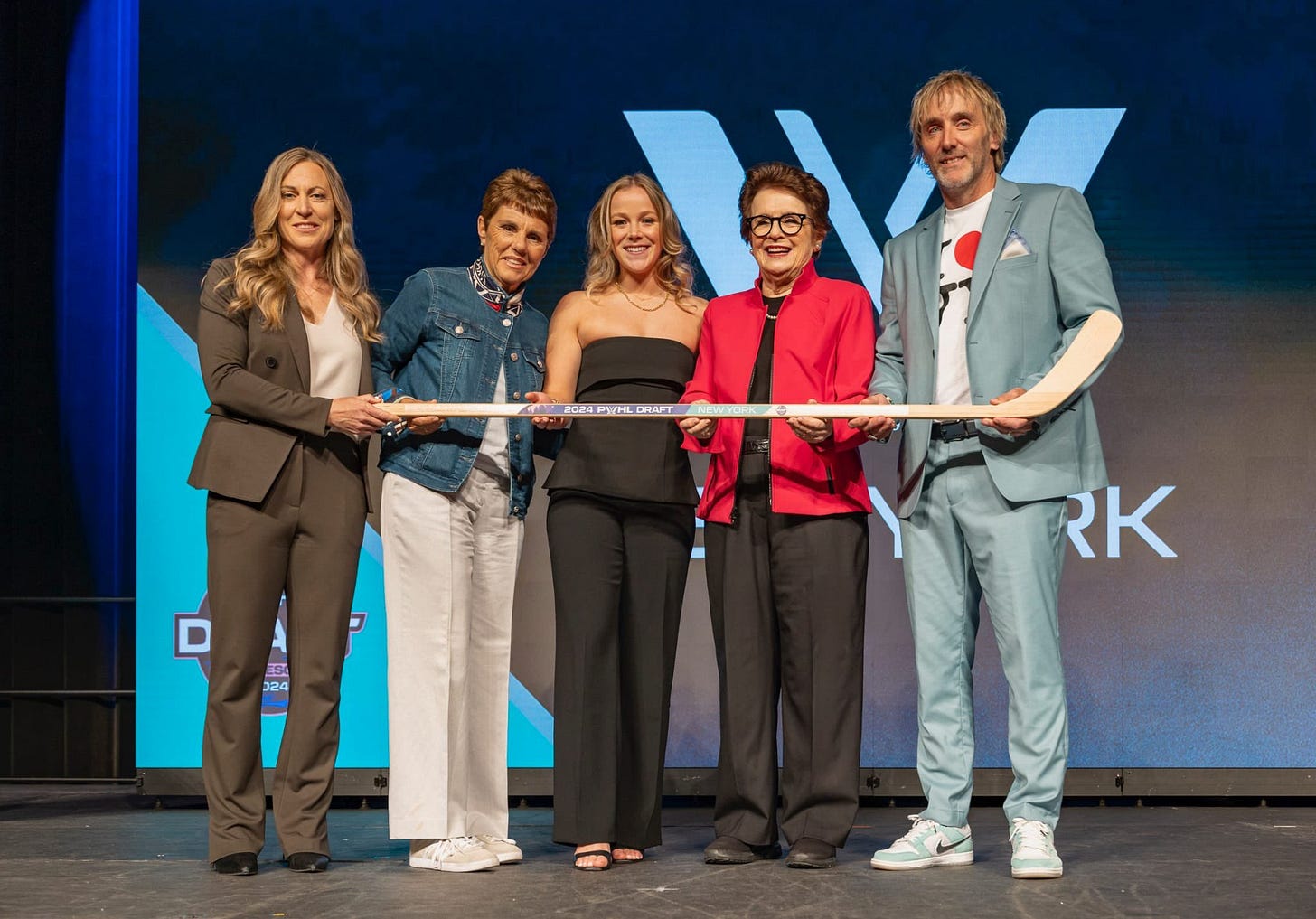 Sarah Fillier poses with executives, all holding a hockey stick together, for a photo shoot after being drafted first overall. Sarah Fillier poses with executives, all holding a hockey stick together, for a photo shoot after being drafted first overall.