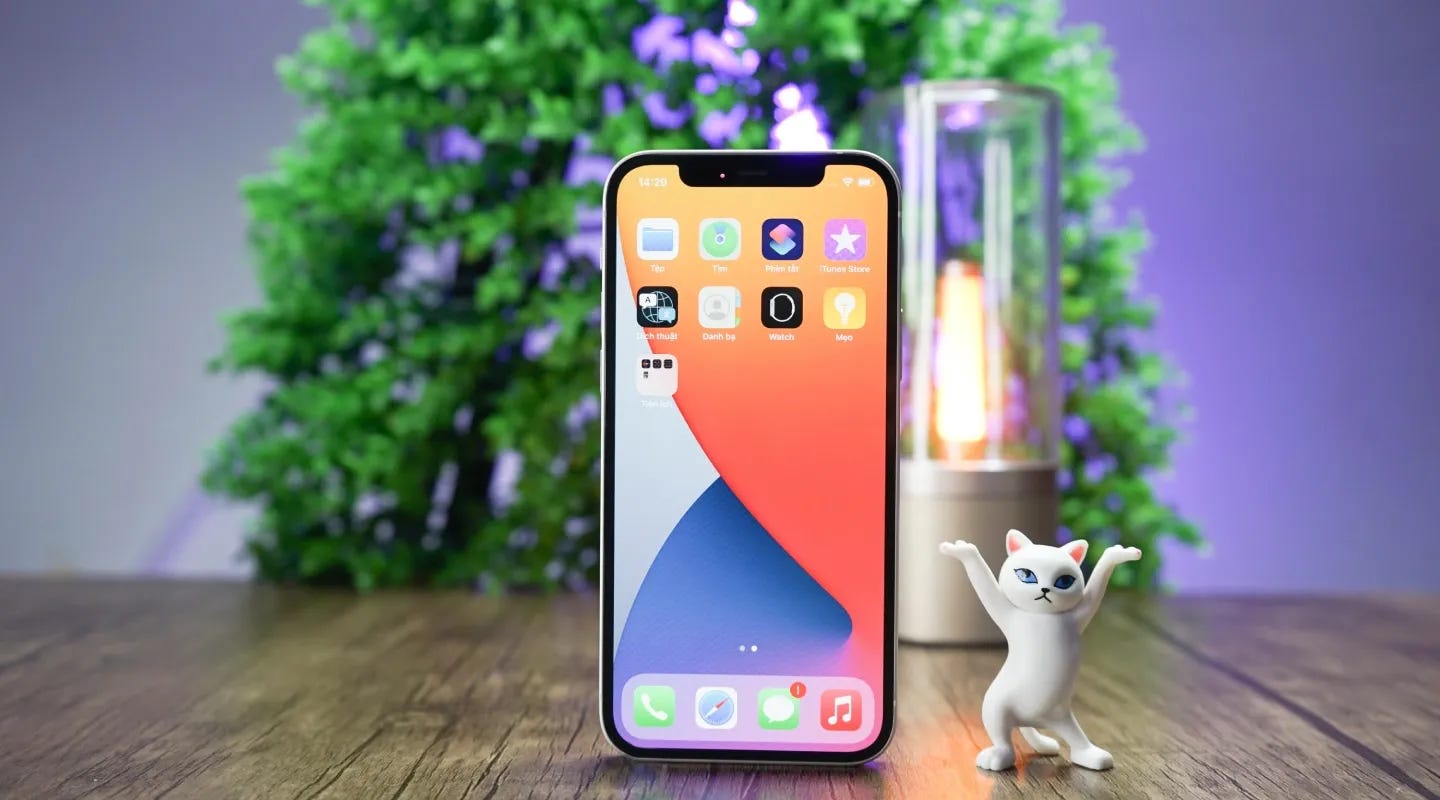 Teléfono celular con un muñequito de gato al lado. Teléfono celular con un muñequito de gato al lado.