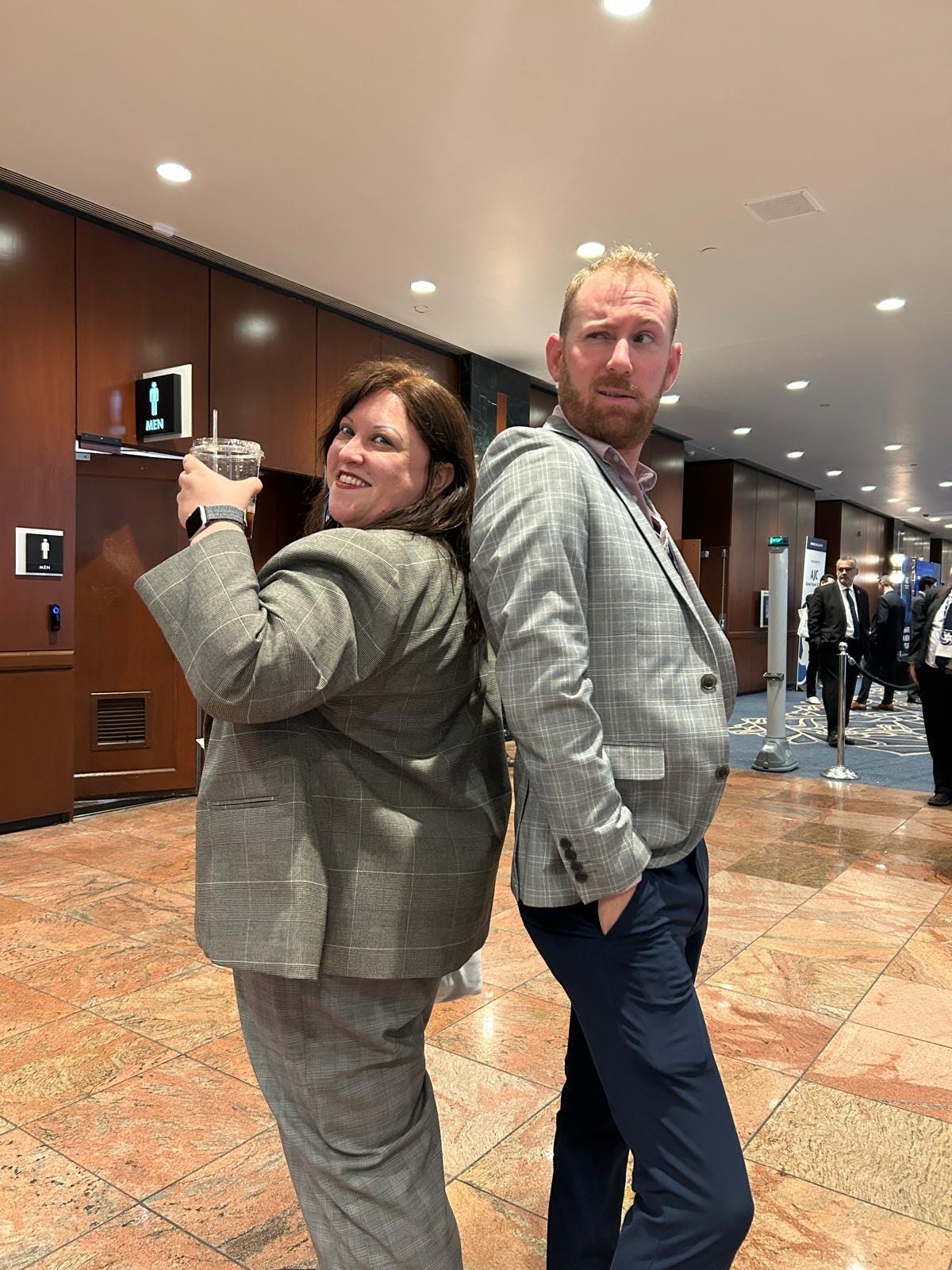 Chedva and Eitam in grey pantsuits in the Mr and Mrs Smith pose