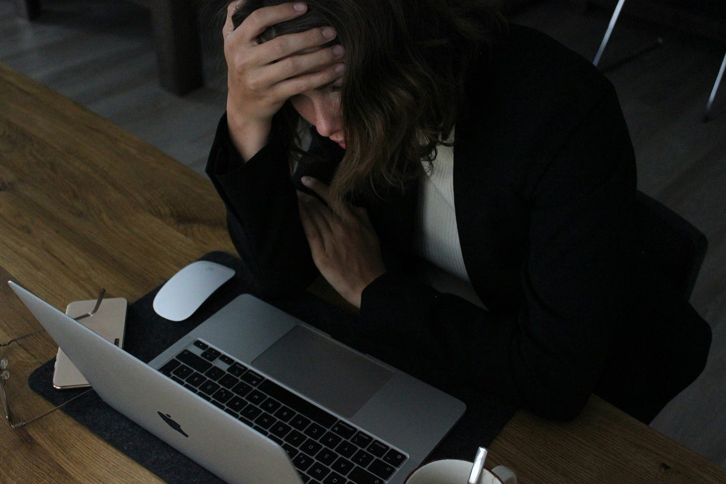 A writer stares at her screen in frustration, head in hands