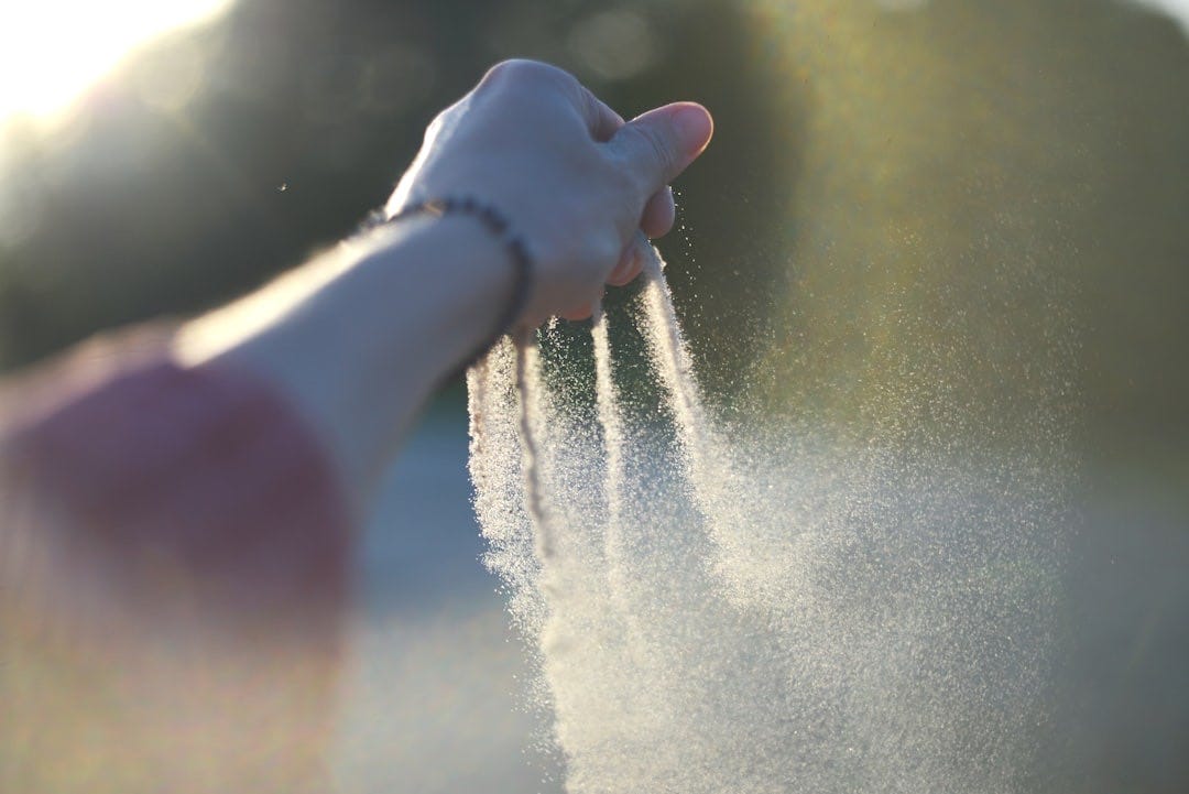 A person holding their hand out to spray water