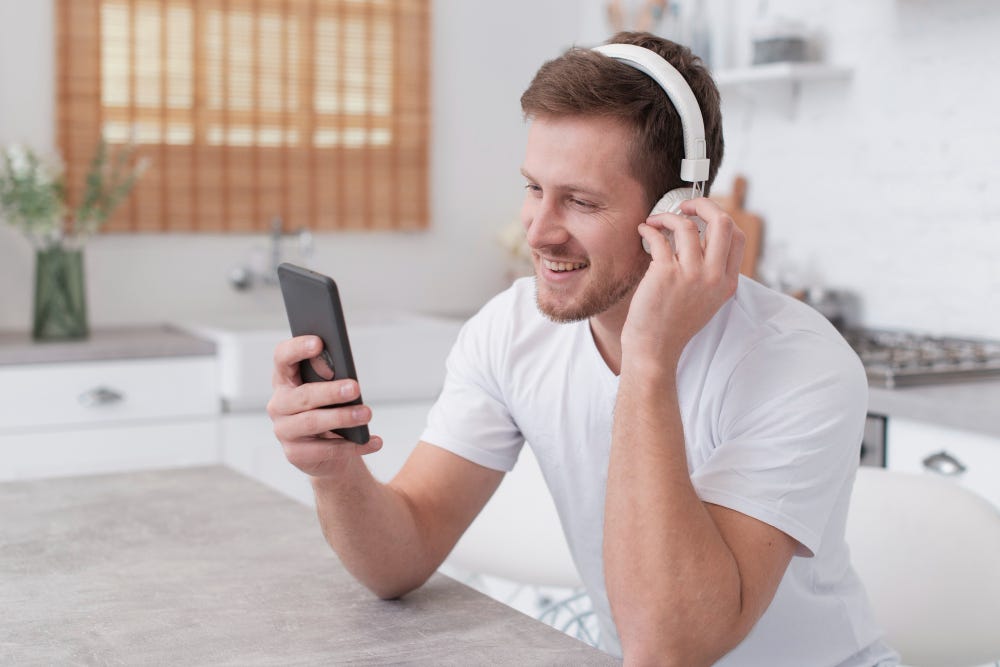 Man listening to music in his kitchen in a morning.
