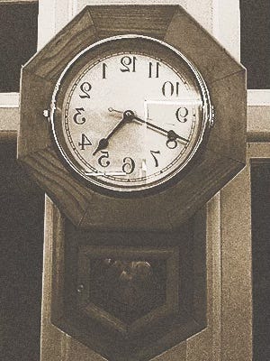 Backwards-facing analogue clock, similar to that in "Alice in Wonderland."