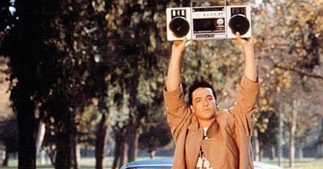 escena de la película say anything en la que el protagonista sostiene un radiocasette con la canción de Peter Gabriel escena de la película say anything en la que el protagonista sostiene un radiocasette con la canción de Peter Gabriel