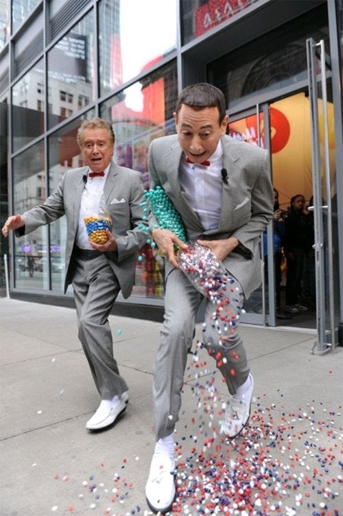 This may contain: two men dressed in suits and bow ties are playing with confetti on the sidewalk