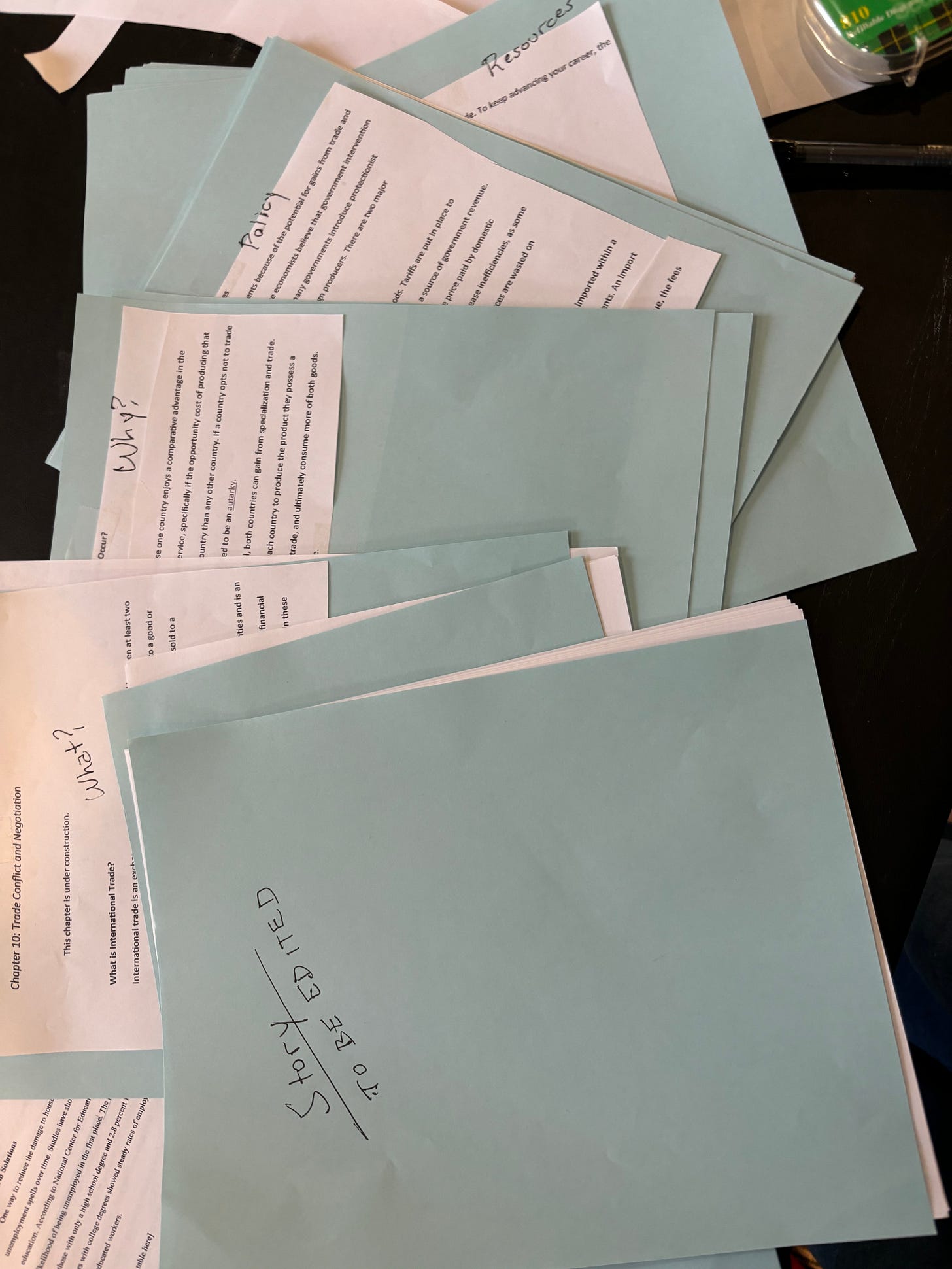 A stack of pages cut onto blue paper and sorted by topic.