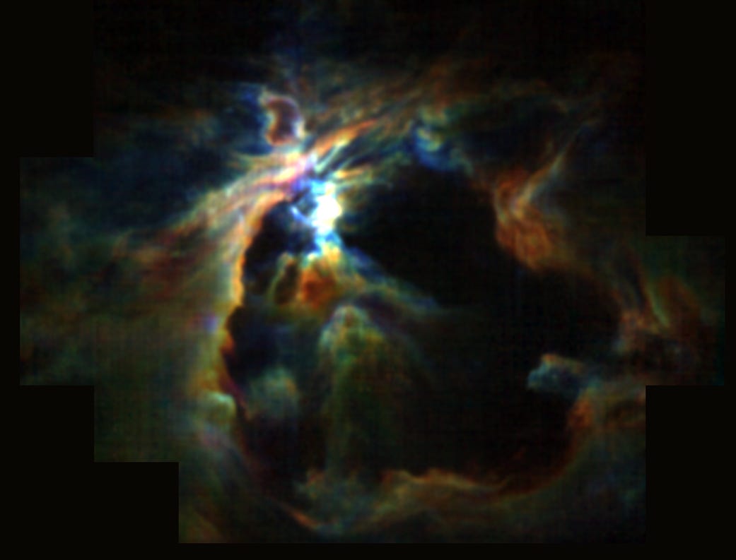 The Orion Nebula showing glowing gas and a dark cavity shaped by stellar winds.