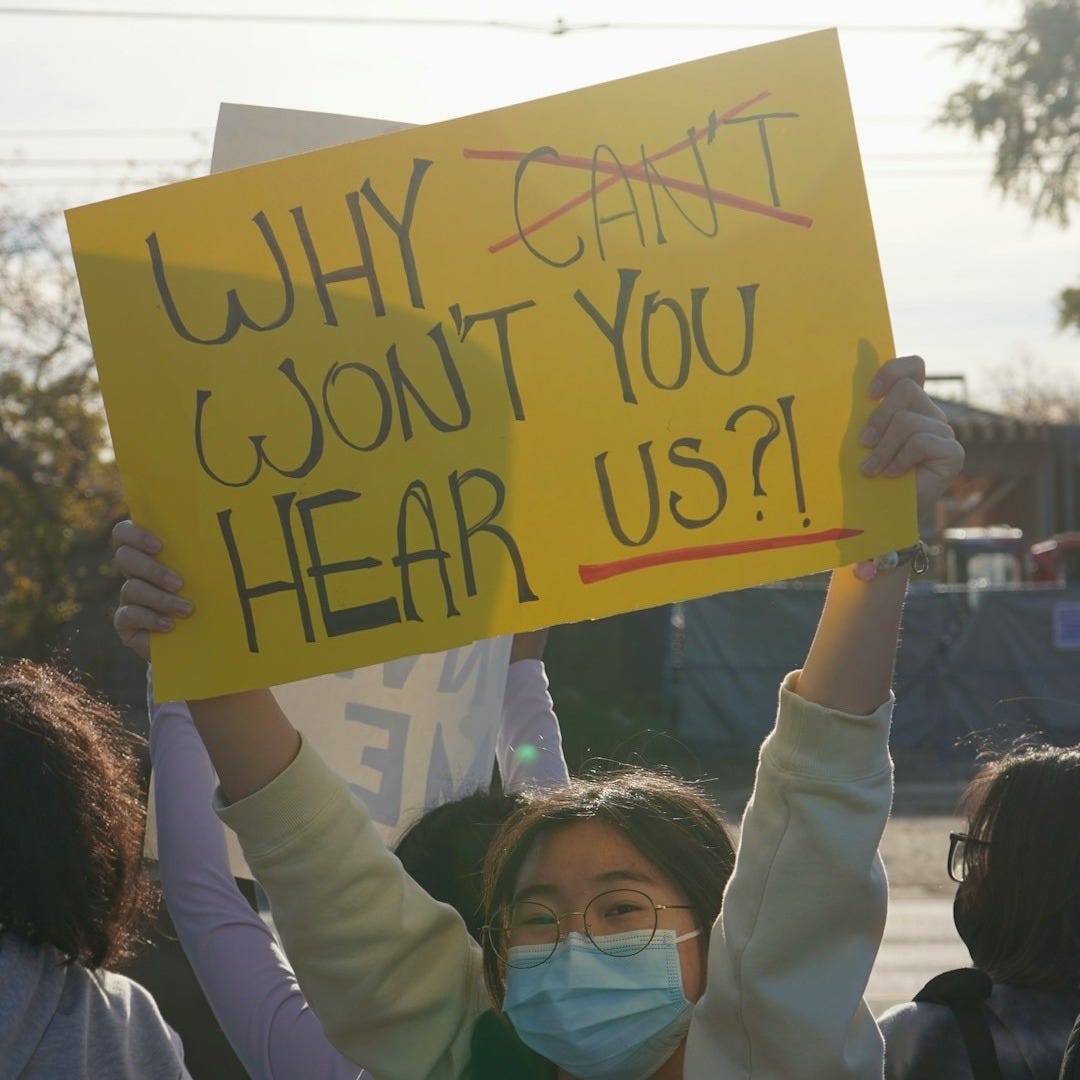 a woman holding a sign that says why can't i don't you