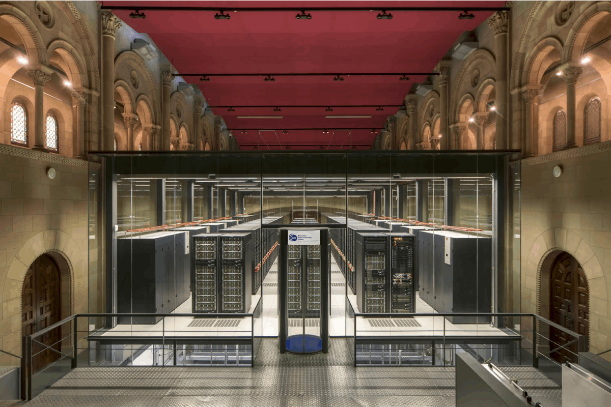 Barcelona Supercomputing Centre, which shows five rows of computer servers with aisles in between, however it is housed in a centuries old chapel with ornate stonework and arches.
