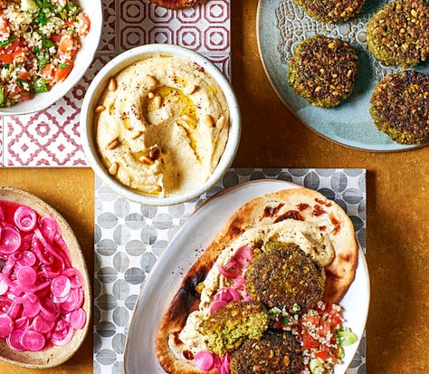 9 different plates of hummus with varying toppings from meatballs to lentils