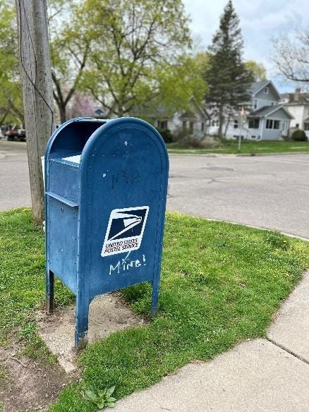 A blue mailbox on the side of a road

AI-generated content may be incorrect.