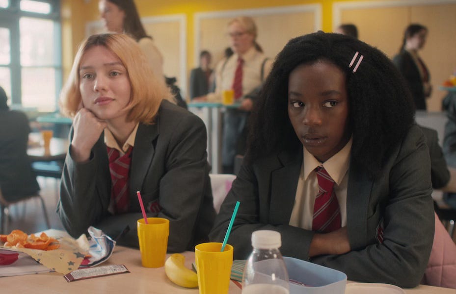 Heartstopper characters Tara and Darcy sit in the school dining hall wth everyone else unaware they are secret lovers Heartstopper characters Tara and Darcy sit in the school dining hall wth everyone else unaware they are secret lovers