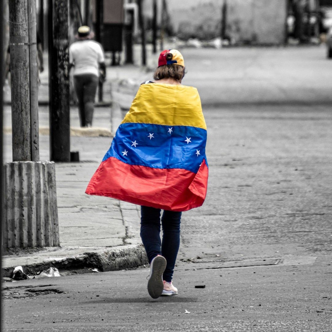 A person walking down a street holding a flag
