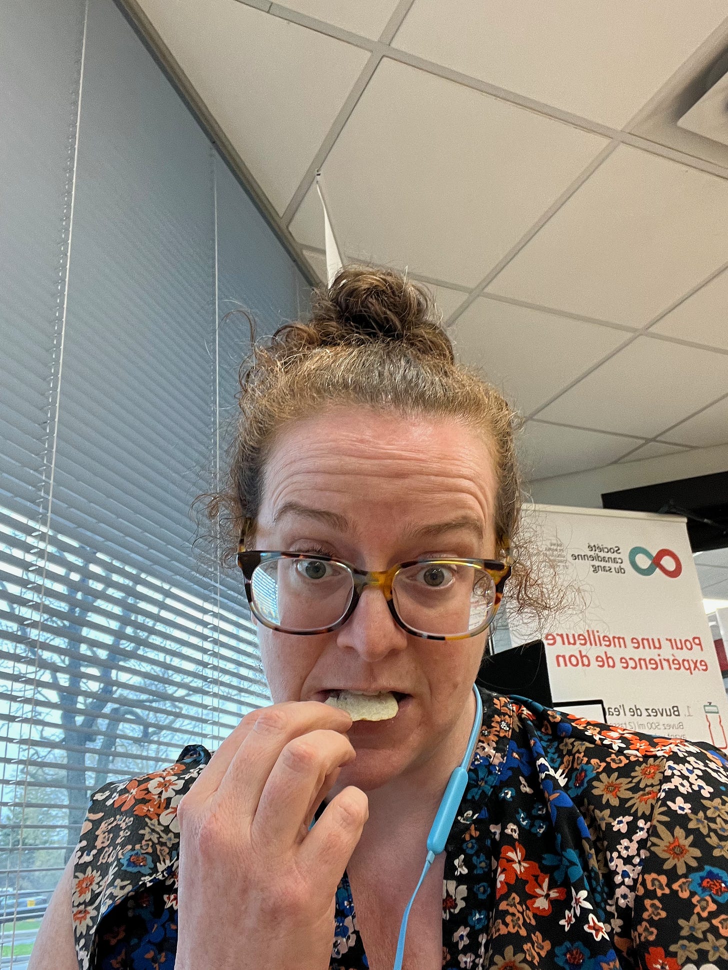 Woman wearing glasses eating a chip