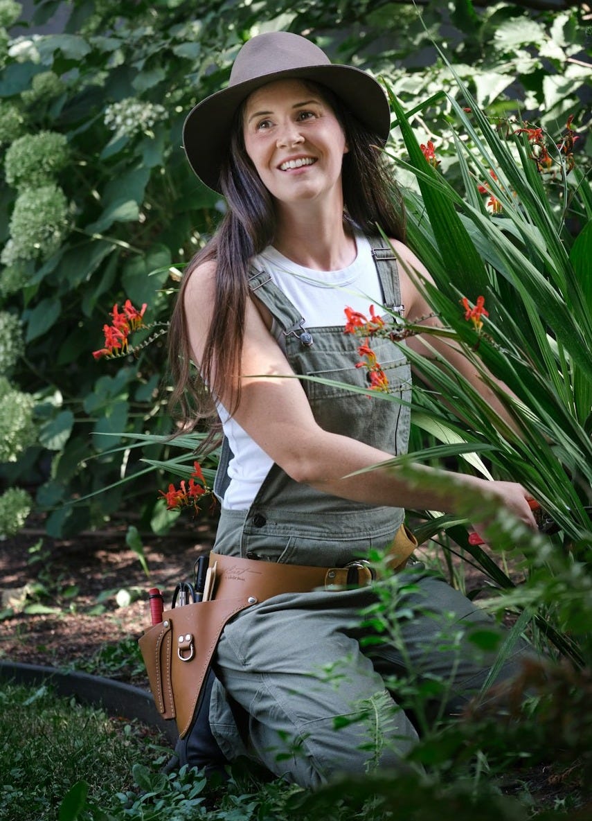 A woman sitting in a garden with a hat on