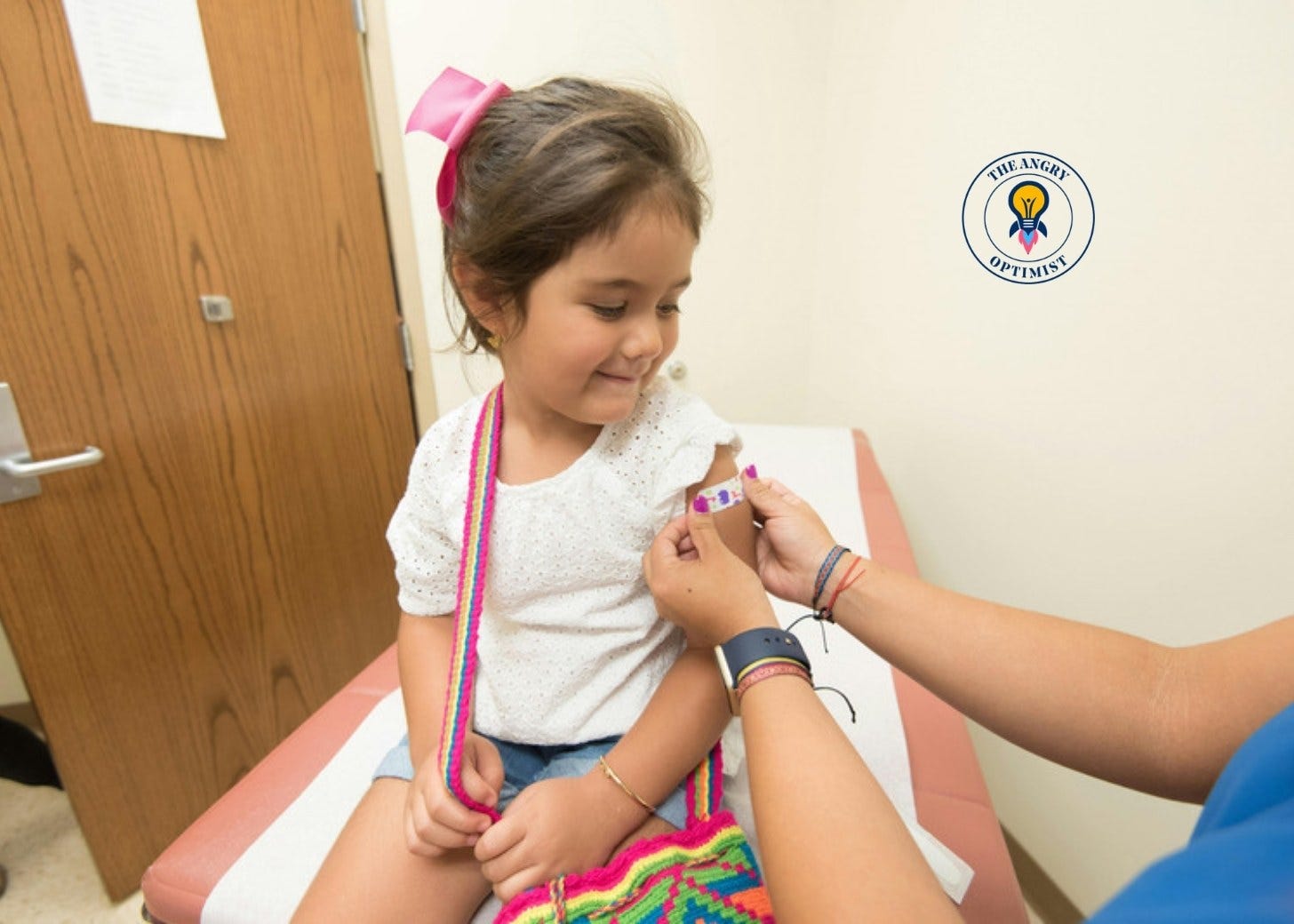 A girl receives a vaccine shot in her arm A girl receives a vaccine shot in her arm