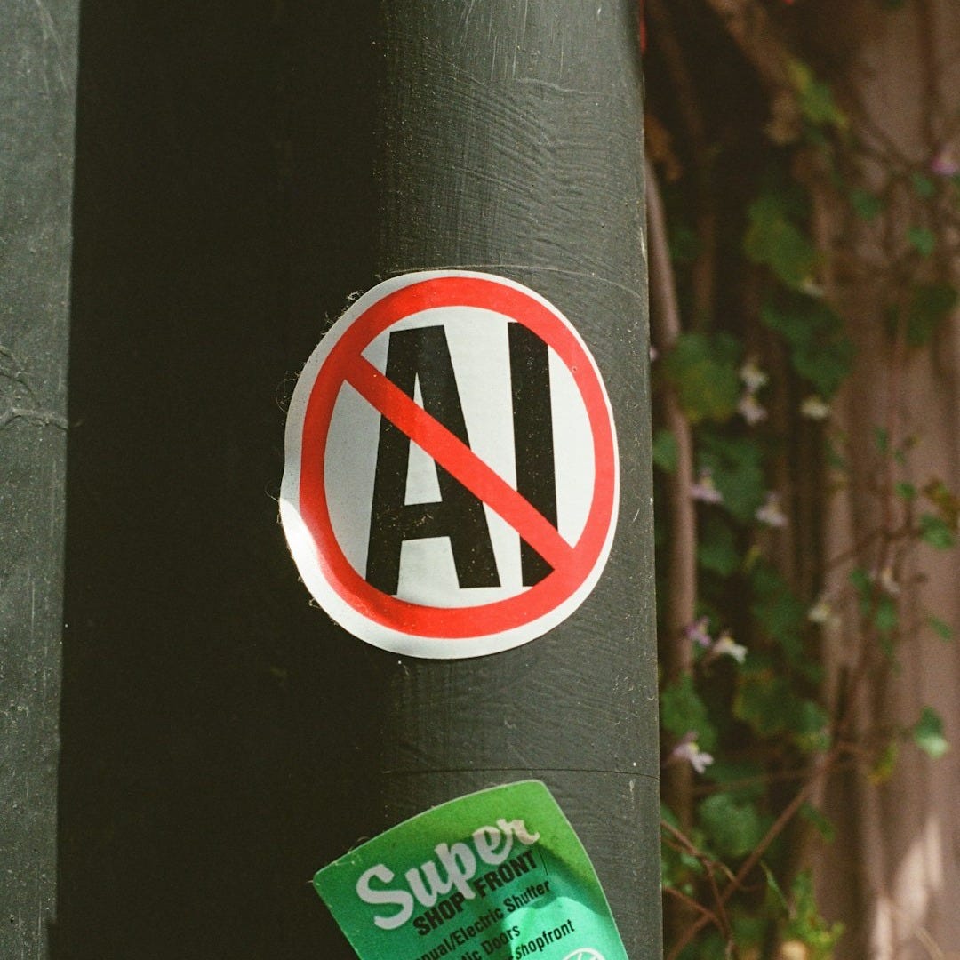 No ai! sticker on a dark pole with green advertisement.