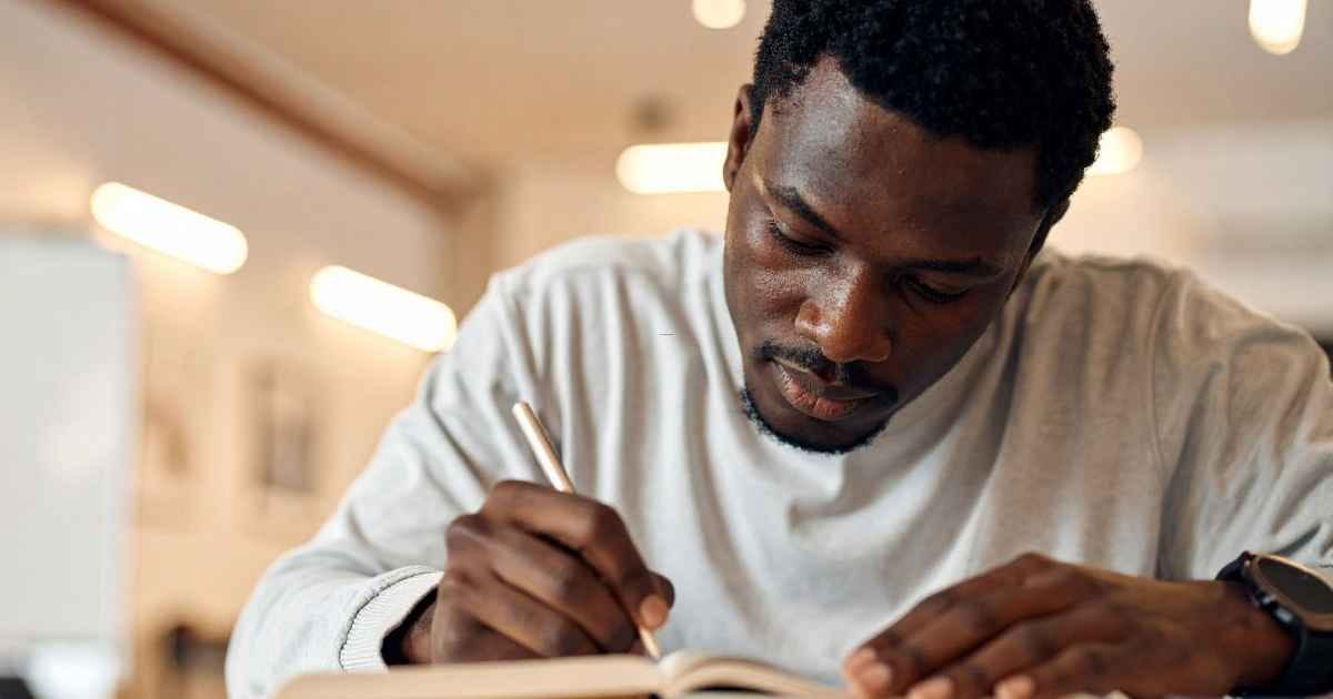 Man Writing in Notebook Close-Up