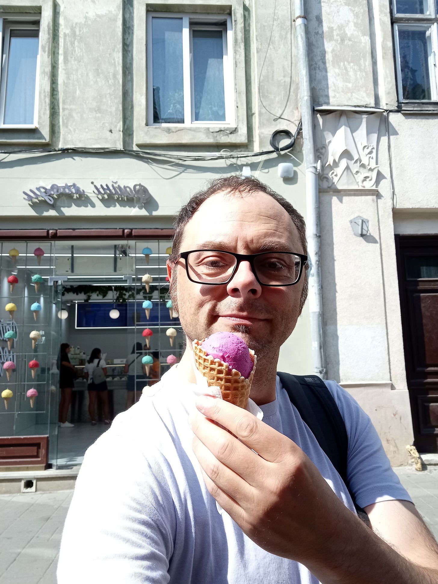 A man holds an icecream cone. A man holds an icecream cone.